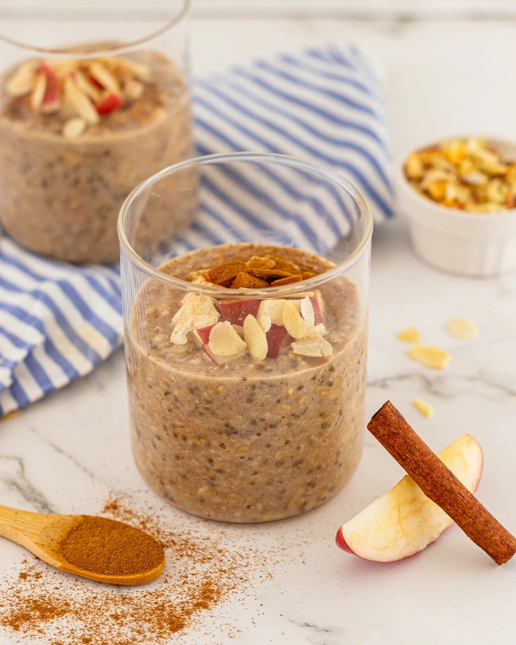 Overnight Oats preparado com maçã, amêndoas e canela em um copo de vidro
